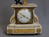 une horloge sur laquelle est posé un oiseau, posée sur une table