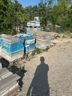 a shadow of a person standing in front of a pile of wood