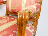 une chaise en bois dont l'assise est recouverte d'un tissu rose et doré