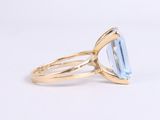 a gold ring with a blue topaz stone in the center