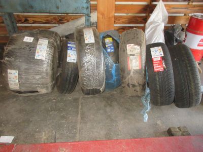 Plusieurs pneus sont alignés les uns à côté des autres dans un garage