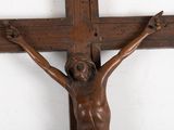 a statue of jesus on a wooden cross on a wall
