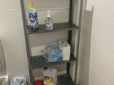 a bathroom with a toilet and a shelf with cleaning products