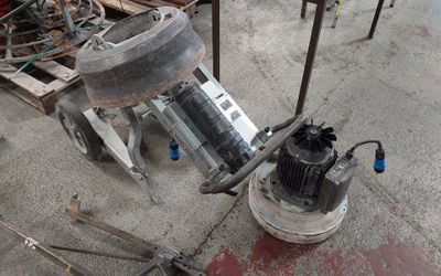 une machine posée par terre à côté d'un tas de bois