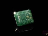an image of a green square shaped stone on a black surface