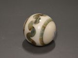 a close up of a white ball with green leaves on it
