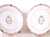 deux assiettes blanches ornées d'une bordure dorée, posées sur un présentoir
