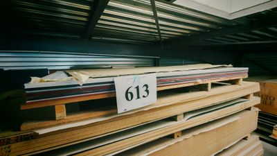Plusieurs piles de bois sont empilées les unes sur les autres dans un entrepôt