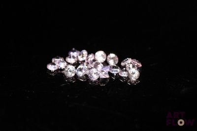 a close up of a bunch of diamonds on a black surface