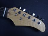 a close up of an electric guitar on a black surface