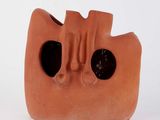a clay sculpture of a face on a white surface