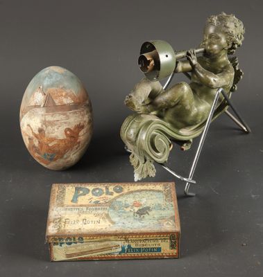 a statue of a child sitting in a chair next to an egg