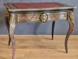 une petite table au plateau rouge posée sur un parquet