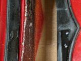 a close up of a red guitar with a black handle