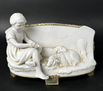 porcelain figurine of a woman sitting on a couch with a dog