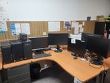 une photo d'un bureau avec trois écrans d'ordinateur et une imprimante