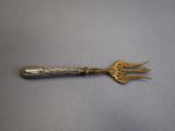 an old silver spoon with a fork on it sitting on top of a table