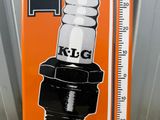 an orange sign with a picture of a spark plug on it