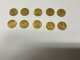 a bunch of gold coins sitting on top of a white table