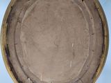 a brown plate sitting on a wooden easel