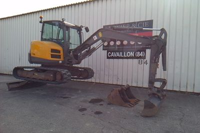 a small excavator that is parked in front of a building