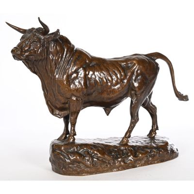 bronze statue of a bull standing on a rock on a white background