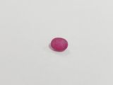 a single pink stone sitting on top of a white surface