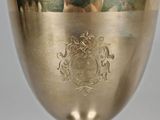 an antique silver cup with a coat of arms on it