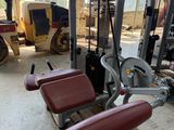 an image of a gym room filled with equipment and a man working on a machine