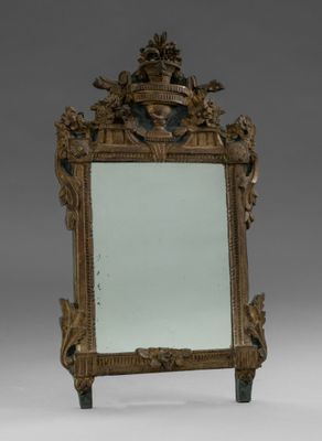 un miroir ancien avec un cadre doré et un motif décoratif