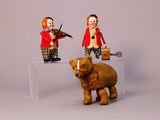 two figurines of clowns and a bear on a table