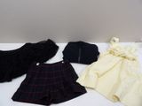 trois vêtements sont posés sur une table à côté d'un sac à main