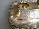 a silver plate with a gold candle holder on top of it