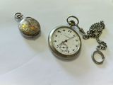 a silver pocket watch and a silver pocket watch on a white surface