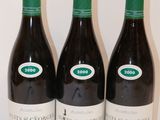 trois bouteilles de vin sont alignées sur une surface blanche