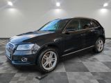 un SUV Audi noir garé sur un sol à damier dans un garage