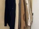 a lot of clothes hanging on a rack in a closet