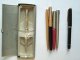 une boîte contenant des stylos, un stylo et un crayon posée sur une table