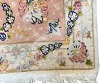 an image of a pink rug with a floral design and fringes on it