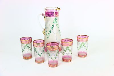 six verres et un pichet posés les uns à côté des autres