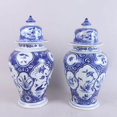 pair of blue and white vases with lids on a white background