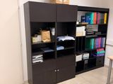 a room with a desk, shelves, and a chair in it