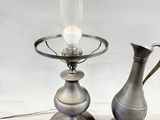 two silver vases sitting next to each other on a table