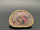 a picture of a gold ring with a red stone in the center