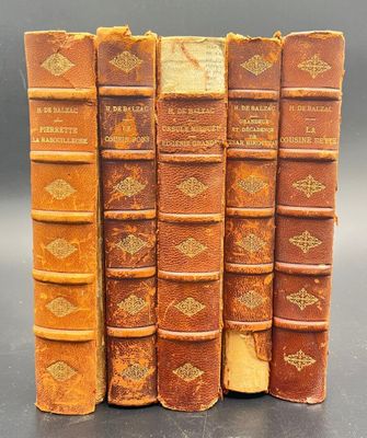 four old books are stacked on top of each other on a table