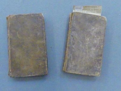 two old books sitting on a blue surface