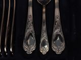 a set of silverware with spoons and spoons on a black cloth
