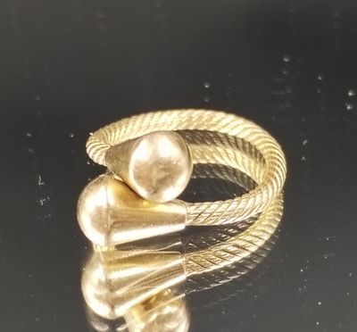 gros plan d'une bague en or sur une surface noire