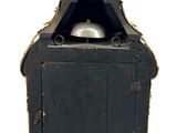 a small black clock with a gold statue on top of it