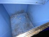 a blue container with dirt in it on the floor